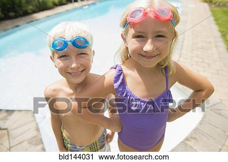Stock Image - Caucasian children smiling near swimming pool. Fotosearch