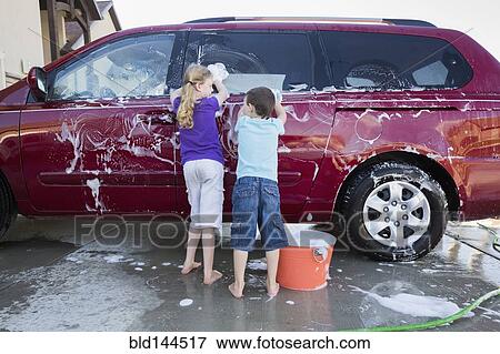 Stock Photo - Caucasian children washing car in driveway. Fotosearch