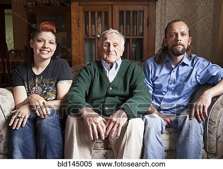 Stock Photography - Caucasian couple and older man smiling on sofa. Fotosearch