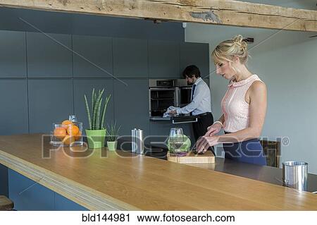 Stock Image - Caucasian couple cooking together in kitchen. Fotosearch
