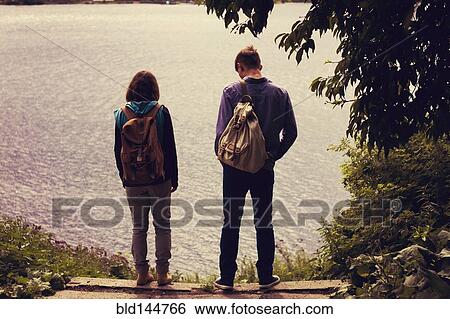 Stock Photograph - Caucasian couple standing near lake. Fotosearch