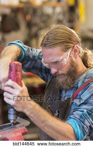 Caucasian craftsman drilling in workshop View Large Photo Image Stock Photography - Caucasian craftsman drilling in workshop. Fotosearch
