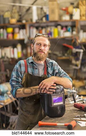 Picture - Caucasian craftsman smiling in workshop. Fotosearch