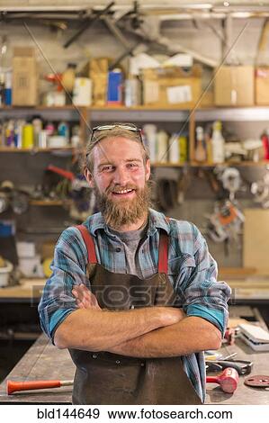 Caucasian craftsman smiling in workshop View Large Photo Image Stock Photo - Caucasian craftsman smiling in workshop. Fotosearch