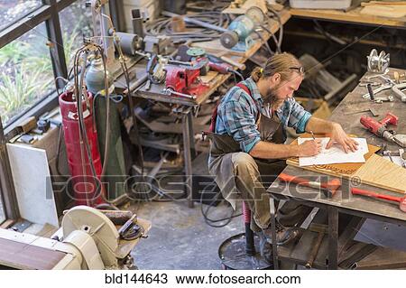 Caucasian craftsman working in workshop View Large Photo Image Stock Image - Caucasian craftsman working in workshop. Fotosearch