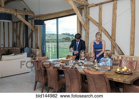 Caucasian family eating dinner in dining room View Large Photo Image Stock Image - Caucasian family eating dinner in dining room. Fotosearch