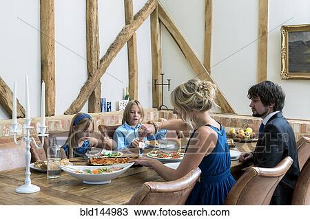 Caucasian family eating dinner in dining room View Large Photo Image Stock Image - Caucasian family eating dinner in dining room. Fotosearch