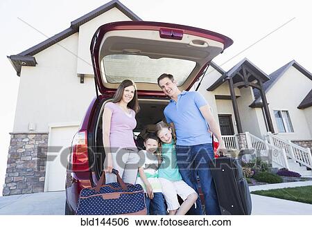 Caucasian family holding suitcases by car View Large Photo Image Stock Photograph - Caucasian family holding suitcases by car. Fotosearch