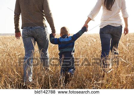 Stock Photo - Caucasian family walking in rural field. Fotosearch