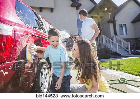 Stock Photo - Caucasian family washing car in driveway. Fotosearch
