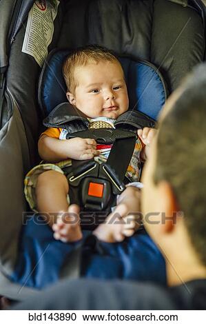 Caucasian father admiring baby boy in car seat View Large Photo Image Stock Image - Caucasian father admiring baby boy in car seat. Fotosearch