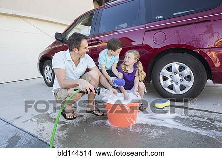 Caucasian father and children washing car in driveway View Large Photo Image Picture - Caucasian father and children washing car in driveway. Fotosearch