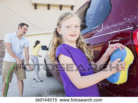 Stock Photography - Caucasian father and children washing car in driveway. Fotosearch