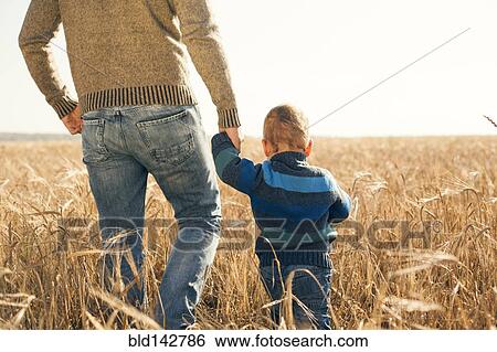 Caucasian father and son walking in rural field View Large Photo Image Stock Photograph - Caucasian father and son walking in rural field. Fotosearch