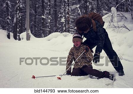 Caucasian father helping cross-country skiing daughter falling in snow View Large Photo Image Stock Image - Caucasian father helping cross-country skiing daughter falling in snow. Fotosearch