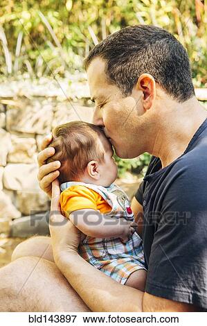 Caucasian father kissing baby boy outdoors View Large Photo Image Stock Photo - Caucasian father kissing baby boy outdoors. Fotosearch