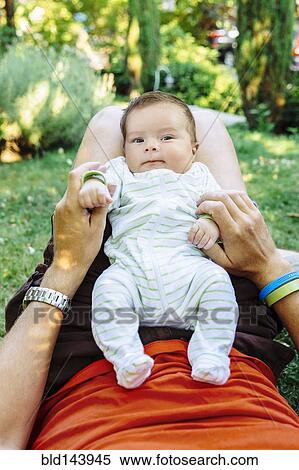 Stock Photography - Caucasian father playing with baby boy in backyard. Fotosearch