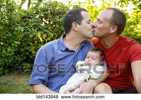 Caucasian gay couple kissing with baby boy in backyard View Large Photo Image Stock Photo - Caucasian gay couple kissing with baby boy in backyard. Fotosearch