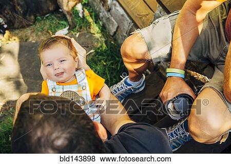 Caucasian gay couple relaxing with baby boy outdoors View Large Photo Image Stock Photo - Caucasian gay couple relaxing with baby boy outdoors. Fotosearch