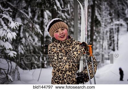 Caucasian girl carrying skis in forest View Large Photo Image Stock Photo - Caucasian girl carrying skis in forest. Fotosearch