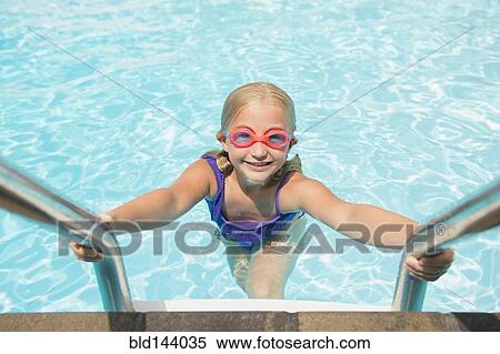 Stock Photography - Caucasian girl climbing out of swimming pool. Fotosearch
