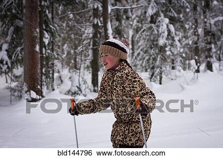 Stock Photograph - Caucasian girl cross-country skiing in forest. Fotosearch