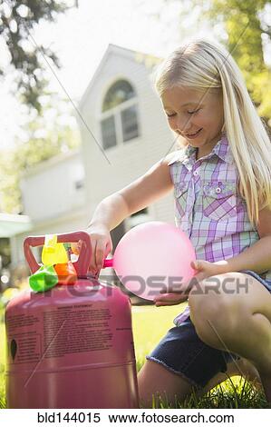 Caucasian girl filling balloons outdoors View Large Photo Image Stock Photography - Caucasian girl filling balloons outdoors. Fotosearch