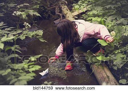 Caucasian girl floating paper boat on forest creek View Large Photo Image Stock Photo - Caucasian girl floating paper boat on forest creek. Fotosearch