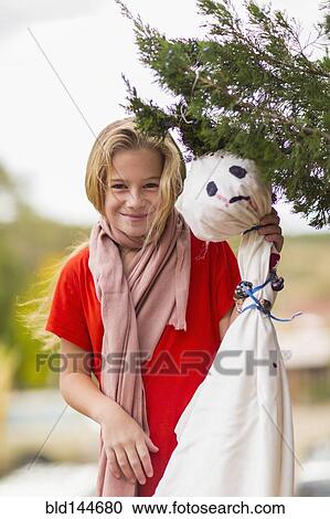 Stock Image - Caucasian girl hanging Halloween decorations. Fotosearch