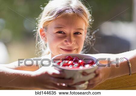 Stock Photography - Caucasian girl holding bowl of fruit. Fotosearch