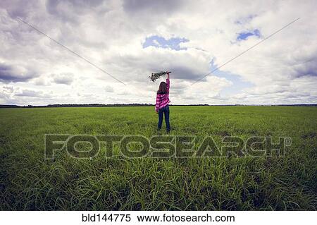 Stock Photography - Caucasian girl playing in grassy field. Fotosearch