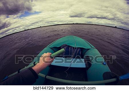 Stock Photo - Caucasian girl rowing canoe on lake. Fotosearch