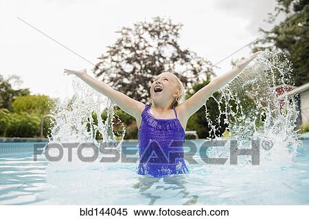 Stock Photography - Caucasian girl splashing in swimming pool. Fotosearch