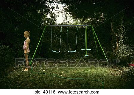 Caucasian girl standing near swing set in backyard View Large Photo Image Stock Photograph - Caucasian girl standing near swing set in backyard. Fotosearch