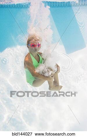 Stock Photo - Caucasian girl swimming underwater in pool. Fotosearch