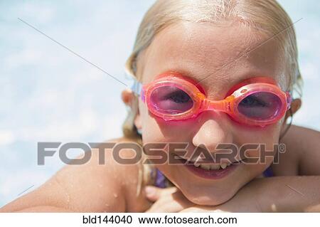 Stock Image - Caucasian girl wearing goggles in swimming pool. Fotosearch