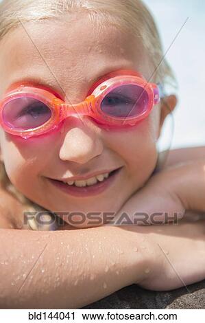 Stock Image - Caucasian girl wearing goggles in swimming pool. Fotosearch