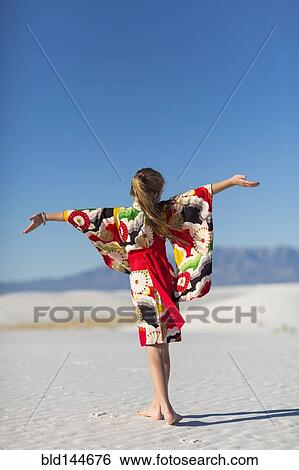 Caucasian girl with arms outstretched on sand dune View Large Photo Image Stock Photograph - Caucasian girl with arms outstretched on sand dune. Fotosearch