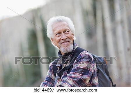 Stock Photo - Caucasian hiker smiling in forest. Fotosearch