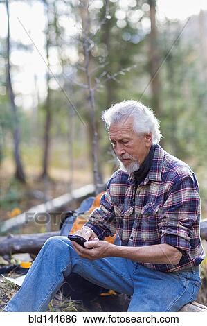 Caucasian hiker using cell phone in forest View Large Photo Image Stock Photograph - Caucasian hiker using cell phone in forest. Fotosearch