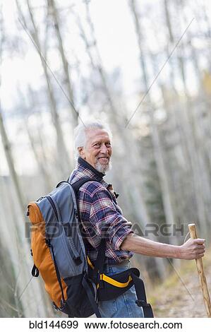 Stock Photo - Caucasian hiker walking on dirt path in forest. Fotosearch