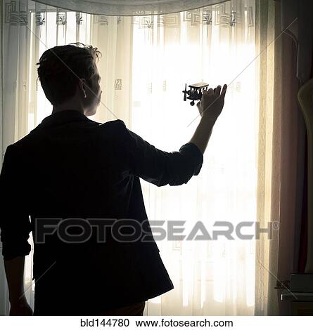 Caucasian man playing with toy airplane near window View Large Photo Image Stock Image - Caucasian man playing with toy airplane near window. Fotosearch