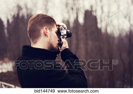 Caucasian man taking photograph outdoors View Large Photo Image Stock Photo - Caucasian man taking photograph outdoors. Fotosearch