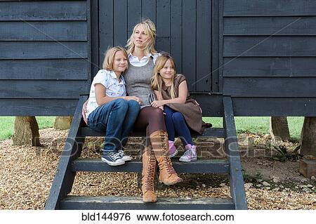 Caucasian mother and children hugging at shed View Large Photo Image Stock Photograph - Caucasian mother and children hugging at shed. Fotosearch