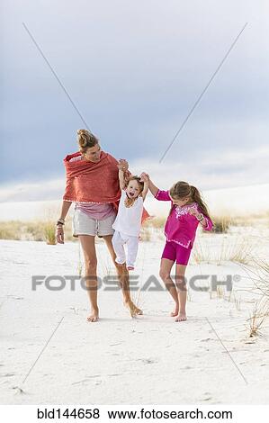 Caucasian mother and children walking on sand dune View Large Photo Image Stock Photo - Caucasian mother and children walking on sand dune. Fotosearch