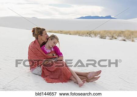 Caucasian mother and daughter wrapped in blanket on sand dune View Large Photo Image Stock Photo - Caucasian mother and daughter wrapped in blanket on sand dune. Fotosearch
