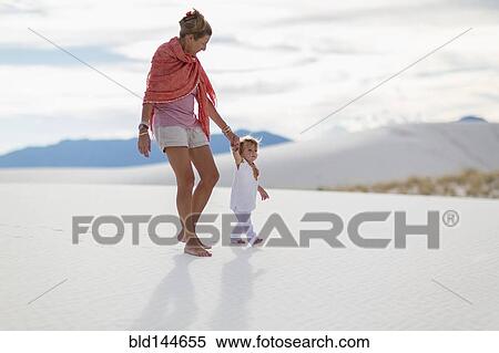 Stock Photography - Caucasian mother and son walking on sand dune. Fotosearch
