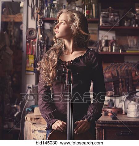 Caucasian teenage girl holding musical instrument in workshop View Large Photo Image Stock Image - Caucasian teenage girl holding musical instrument in workshop. Fotosearch