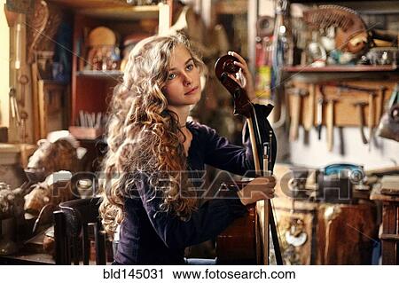 Caucasian teenage girl holding musical instrument in workshop View Large Photo Image Stock Image - Caucasian teenage girl holding musical instrument in workshop. Fotosearch