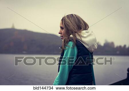 Picture - Caucasian woman admiring scenic lake view. Fotosearch